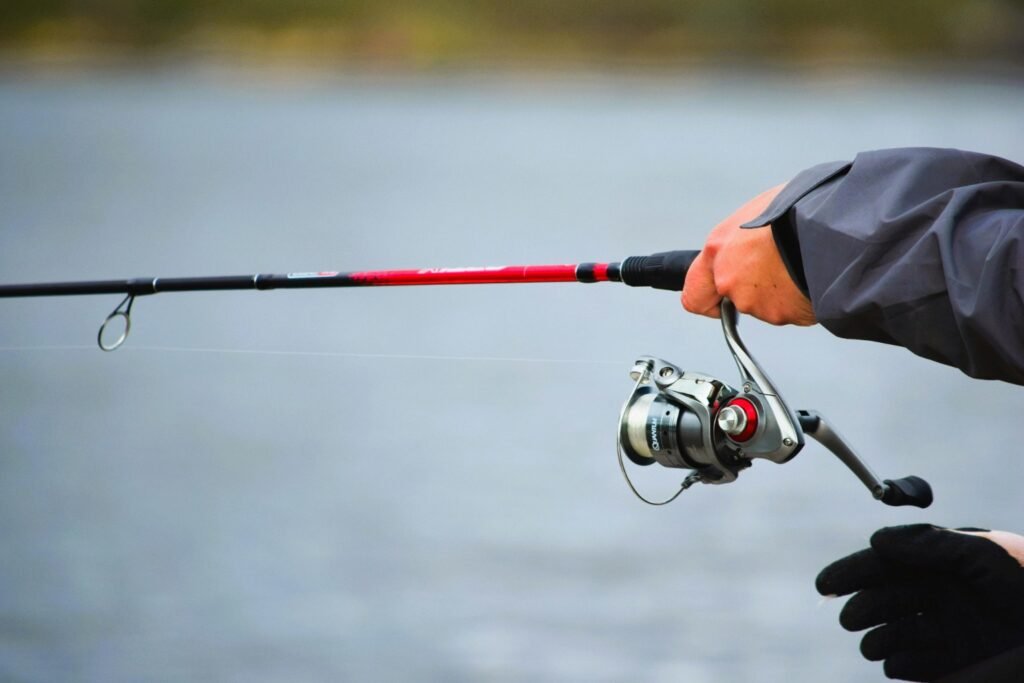 Fishing for Beginners: A Simple, Stress-Free Way to Start Close-up of a beginner holding a spinning rod and reel while fishing from the shoreline.
