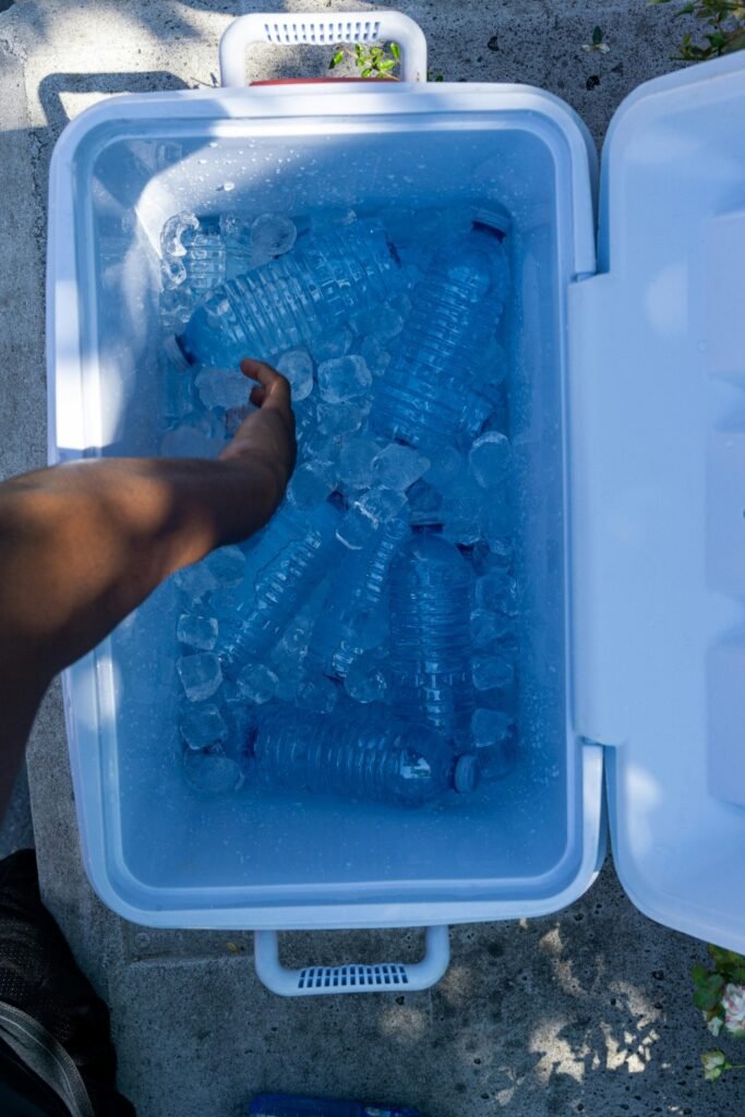 Camping cooler filled with ice and water bottles to keep food cold